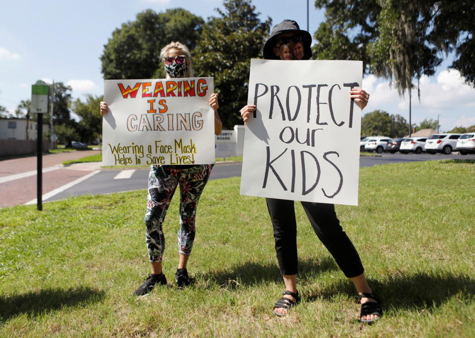 Personas apoyan el uso de mascarillas en las escuelas se manifiestan en Largo, Florida. (Reuters)