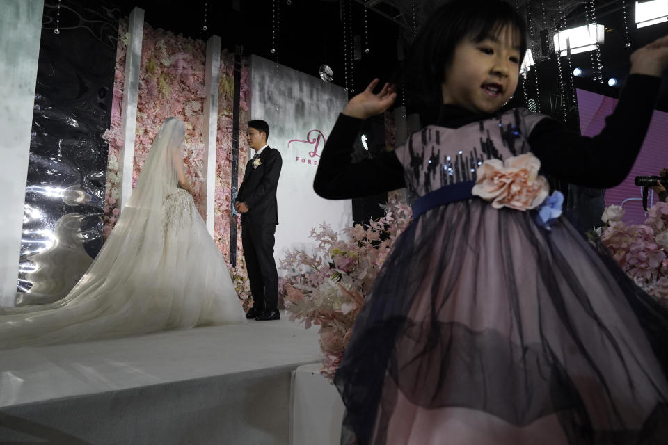 A child reacts as bride Chen Yaxuan and groom Dou Di exchange vows during an unmasked wedding banquet in Beijing on Saturday, Dec. 12, 2020. Lovebirds in China are embracing a sense of normalcy as the COVID pandemic appears to be under control in the country where it was first detected. (AP Photo/Ng Han Guan)