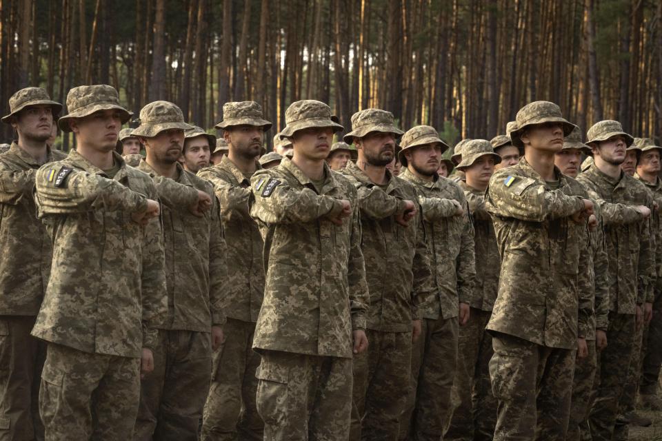 Newly recruited soldiers of Ukraine's 3rd Assault Brigade shout slogans at a military base close to Kyiv, Ukraine, Monday, Sept. 25, 2023. The loss of the city of Avdiivka in February 2024 marked the end of a long, exhausting defense for the Ukrainian military. One brigade had defended the same block of buildings for months without a break. Another unit had been in the city for nearly two years. (AP Photo/Efrem Lukatsky)