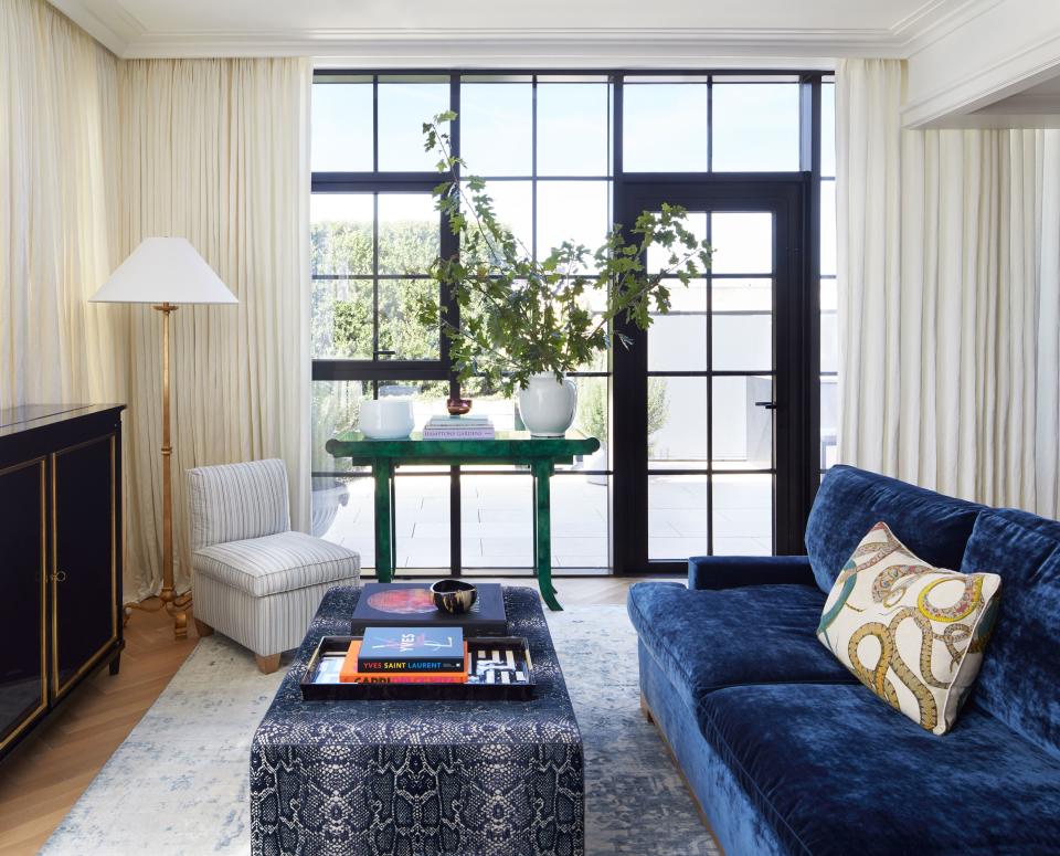 In the family room, a custom sofa from Jonas covered in Romo turquoise velvet floats above a silk Tabriz carpet.