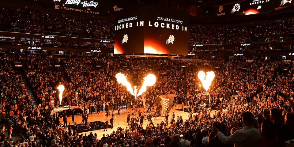 Crowds inside of the Phoenix Suns' Footprint Center watch as flames go off during starting introductions.