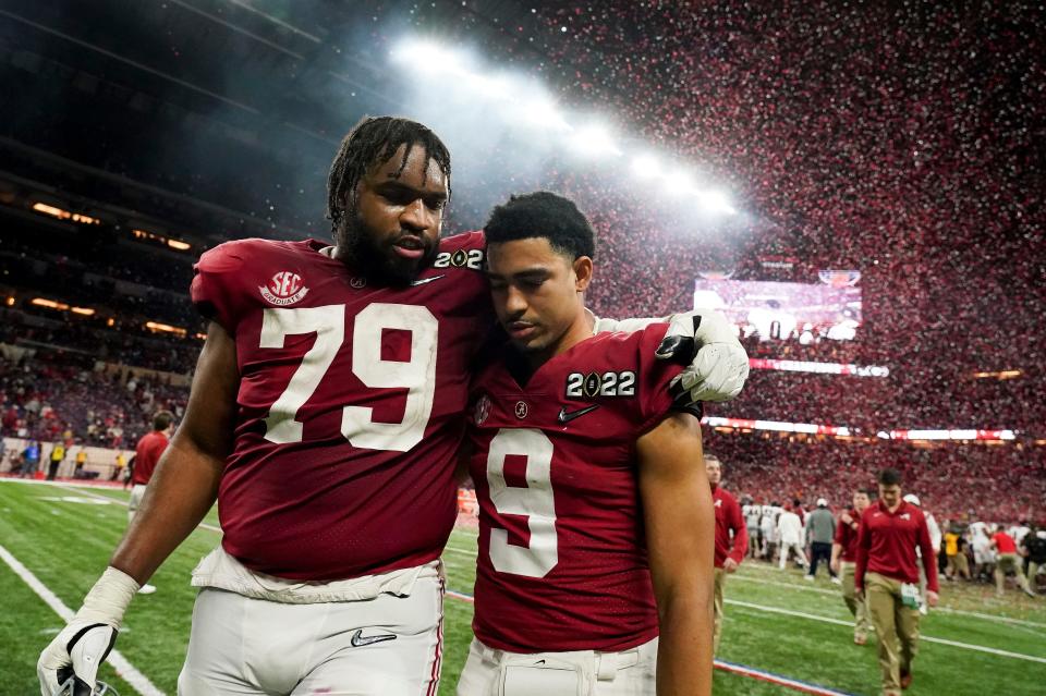 Alabama QB Bryce Young leaves the field with former Crimson Tide offensive lineman Chris Owens following the title game loss to Georgia in January.