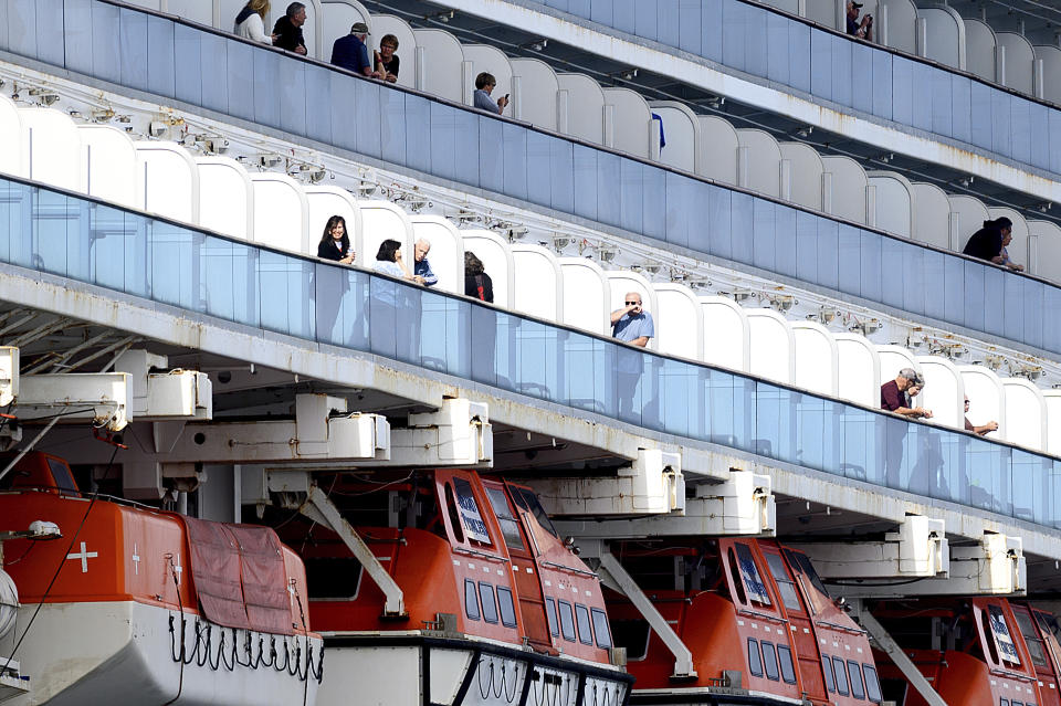 Passengers look out from balconies aboard the Grand Princess as it cruises a holding pattern about 25 miles off the coast of San Francisco on Sunday, March 8, 2020. The ship is expected to dock in Oakland in the east San Francisco Bay on Monday. California Gov. Gavin Newsom and the mayor of Oakland sought Sunday to reassure the public that none of the passengers from the ship with multiple cases of the new coronavirus will be released into the public before undergoing a 14-day quarantine. (AP Photo/Noah Berger)