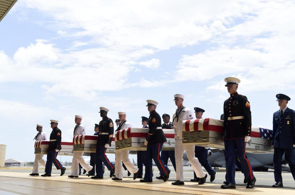 Military members carry transfer cases from a C-17 at a ceremony marking the arrival of the remains believed to be of American service members who fell in the Korean War at Joint Base Pearl Harbor-Hickam in Hawaii, Wednesday, Aug. 1, 2018. North Korea handed over the remains last week. (AP Photo/Susan Walsh)