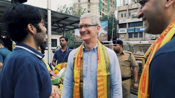 Apple CEO Tim Cook, center, interacts with Anant Ambani, left, son of industrialist Mukesh Ambani, outside Siddhivinayak Hindu Temple in Mumbai, India, Wednesday, May 18, 2016.