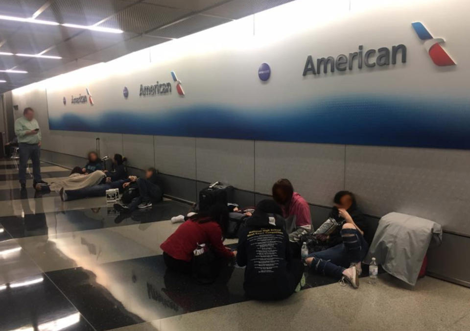 Nine high school students and 11 adults were forced to sleep on the floor at baggage claim after American Airlines cancelled their flight home. (Photo: Facebook)