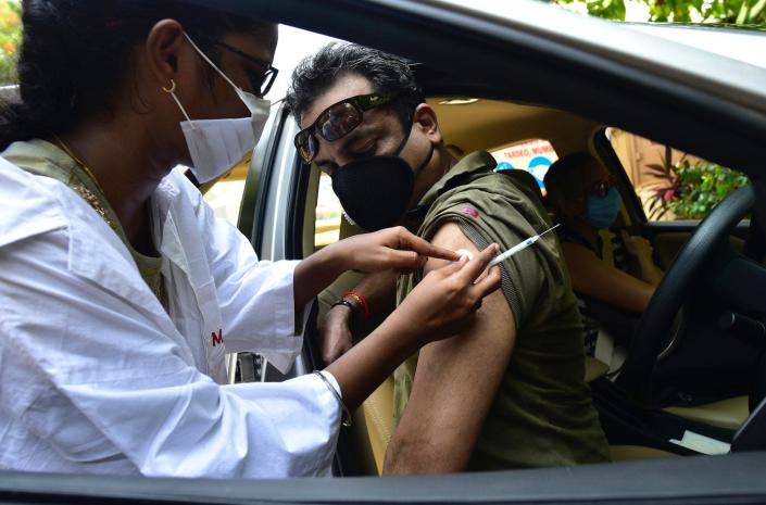 A passenger receives his COVID-19 vaccine at a drive-in vaccine clinic on May 8, 2021 in Mumbai, India.