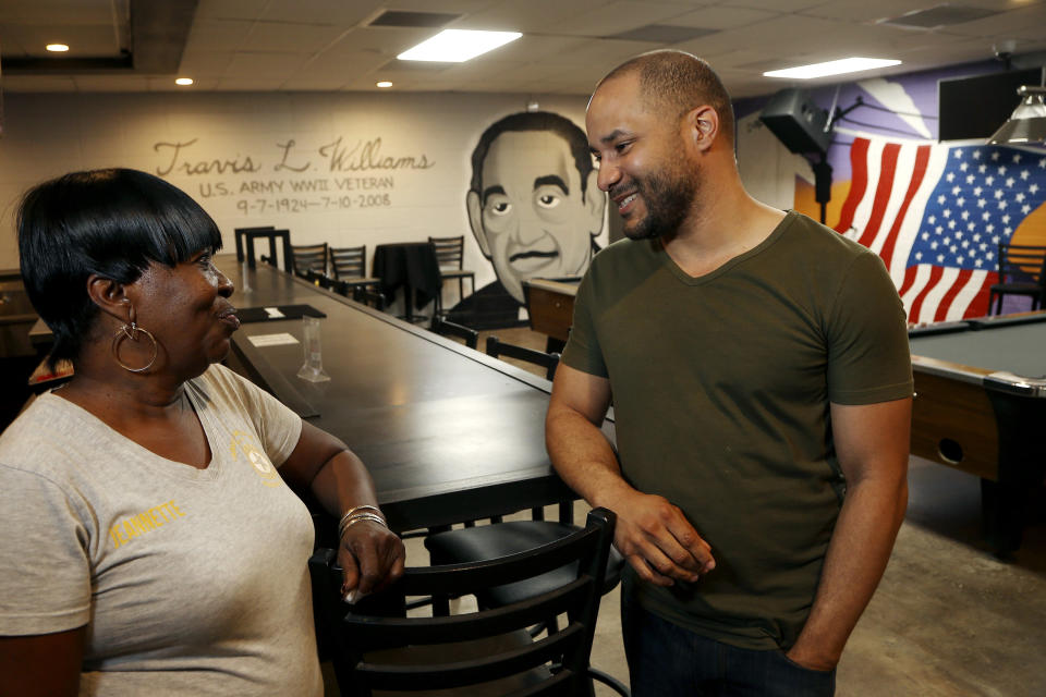 In this Tuesday, July 30, 2019 photo, activist Lawrence Robinson, right, talks with Jeanette Murphy, at the Post 65 American Legion hall, formed during the era of segregation and recently renovated in Phoenix. Three American Legion posts stand within miles of each other in central Phoenix, a curious reminder of how segregation once ruled the U.S. Southwest as well as the Deep South. Post 65 draws a largely black crowd. “It’s affordable, and there is camaraderie,” said Robinson, who attends legion events with friends. (AP Photo/Ross D. Franklin)