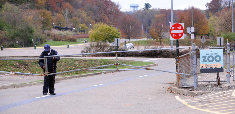 A security guard closes the gate at the Pittsburgh Zoo, where zoo officials say a young boy was killed after he fell into the exhibit that was home to a pack of African painted dogs, who pounced on the boy and mauled him, Sunday, Nov. 4, 2012. It’s not clear whether he died from the fall or the attack, said Barbara Baker, president and CEO of the Pittsburgh Zoo & PPG Aquarium. (AP Photo/John Heller)