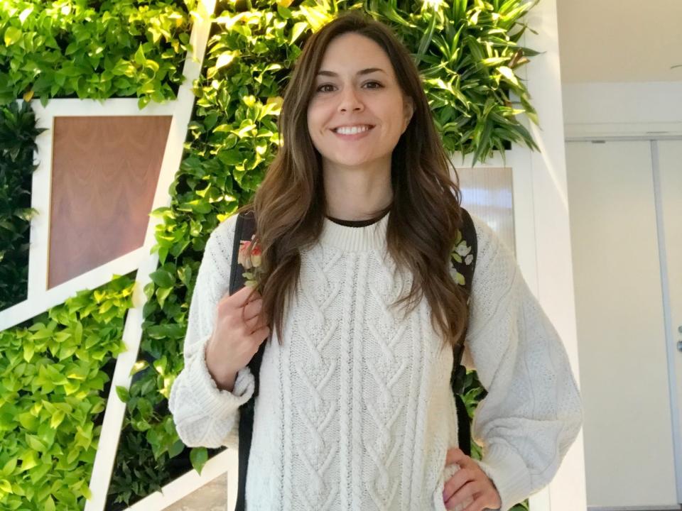 Woman wearing a white sweater smiling for a photo