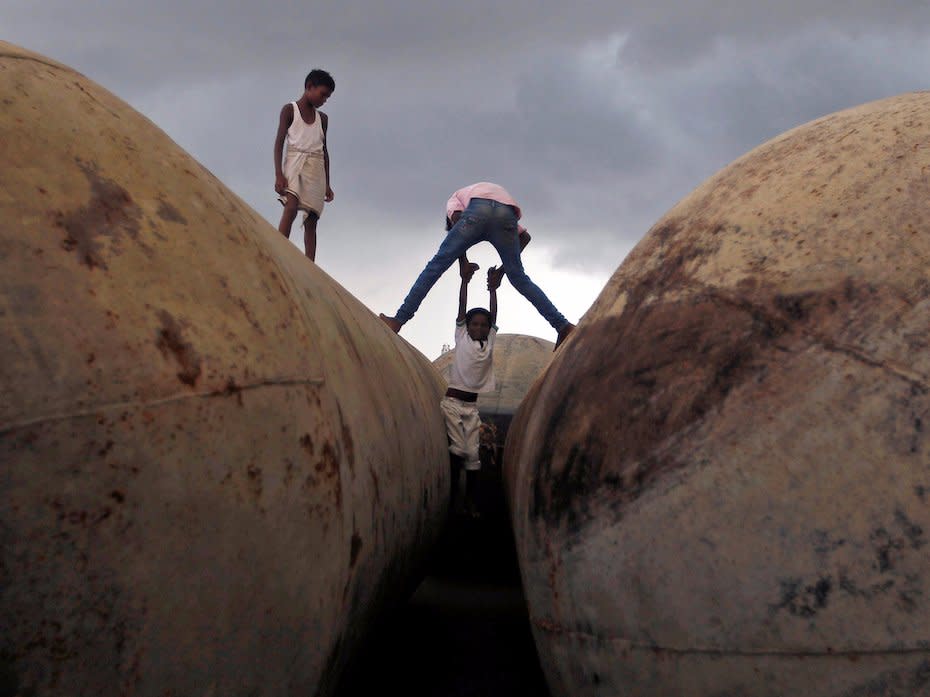 Children play on pontoons as clouds gather over the banks of the river Ganges in Allahabad, India August 30, 2016.