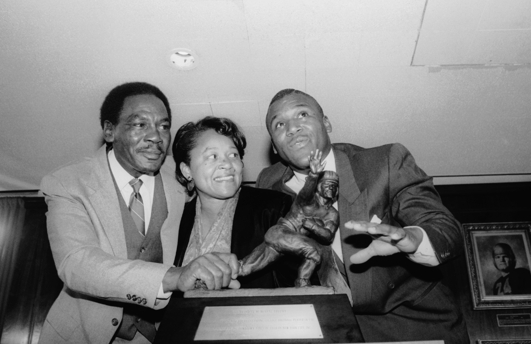 Heisman Trophy winner Barry Sanders and his parents stand by the trophy.