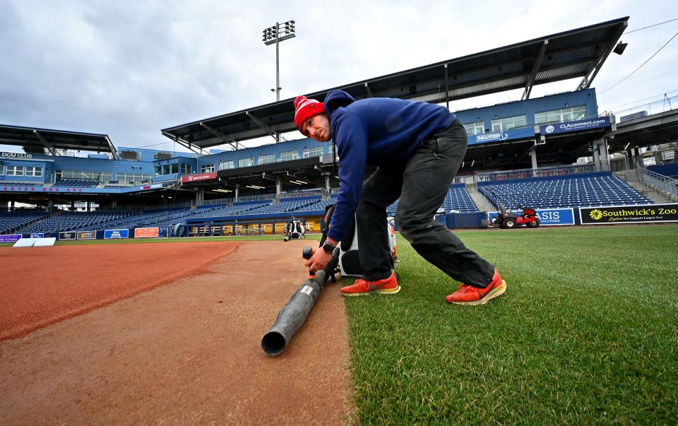 Polar Park assistant field superintendent Ryan Lefler sets up a leaf blower to dry off wet sand in the infield as grounds crew get ready on Tuesday for opening day on Friday.