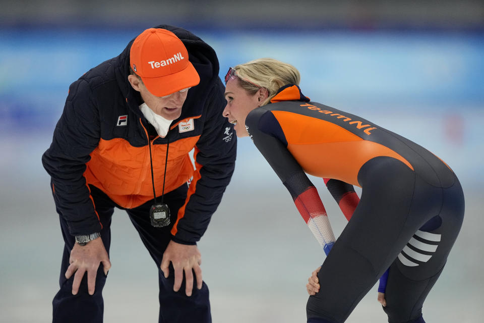 Irene Schouten of the Netherlands reacts with a coach after winning the gold medal and breaking the Olympic record in the women's speedskating 3,000-meter race at the 2022 Winter Olympics, Saturday, Feb. 5, 2022, in Beijing.(AP Photo/Ashley Landis)