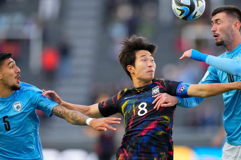 Lee Seung-won, el capitán de Corea del Sur, lucha por la pelota con  Sean Edri y Hadar Fuchs.