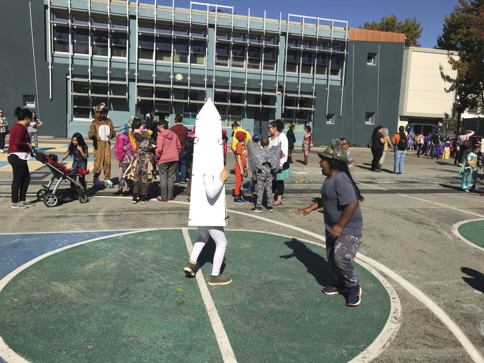Children at Washington Elementary in Berkeley, Calif., play during the school's annual Halloween costume parade outside on Thursday, Oct. 31, 2019. The school had considered holding the parade indoors if the air quality was questionable because of a massive wildfire in Northern California's wine country. For tens of thousands of children in California, the biggest monsters this Halloween are wildfires that have thrown trick-or-treating into disarray. (AP Photo/Liz Schultz)