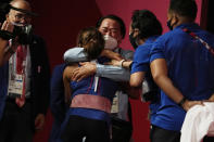 Hidilyn Diaz of Philippines celebrates with Weightlifting Philippines federation president Monico Puntuevella after winning the gold medal in the women's 55kg weightlifting event, at the 2020 Summer Olympics, Monday, July 26, 2021, in Tokyo, Japan. (AP Photo/Luca Bruno)