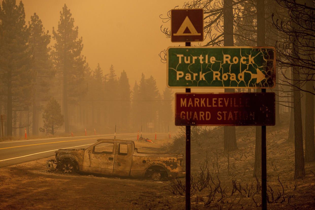 A scorched car rests on a roadside as the Tamarack Fire burns in Alpine County, Calif., on Saturday. (AP Photo/Noah Berger)