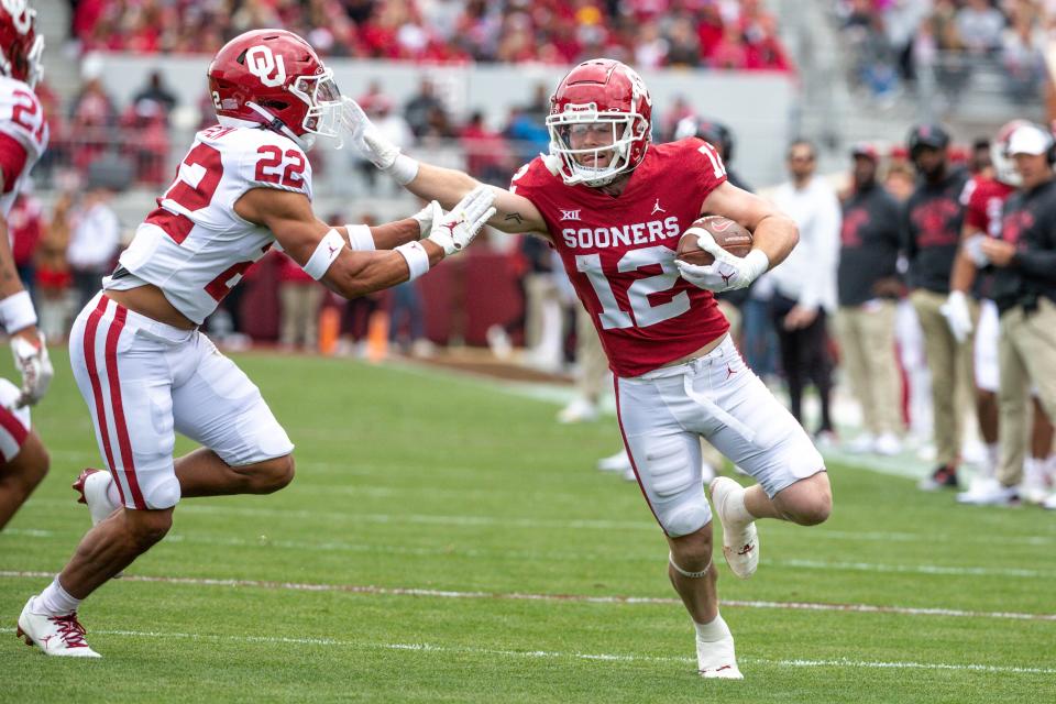 Oklahoma Red Team's Drake Stoops (12) stiff arms Oklahoma White Team's Peyton Bowen (22) during a spring scrimmage game at Gaylord Family Oklahoma Memorial Stadium in Norman Okla., on Saturday, April 22, 2023.