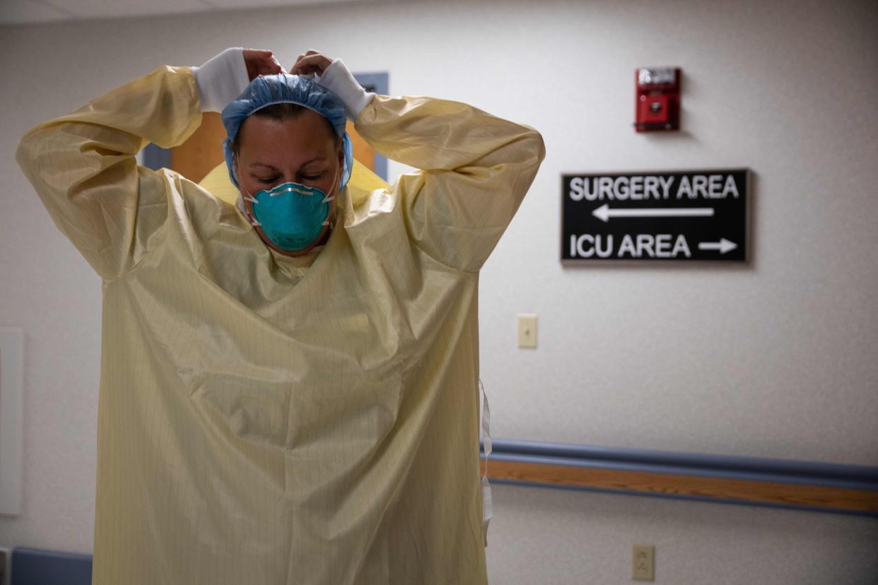 A healthcare professional suits up with PPE (Personal Protective Equipment) to enter a Covid-19 patient's room in the ICU at Van Wert County Hospital in Van Wert, Ohio on Nov. 20, 2020.