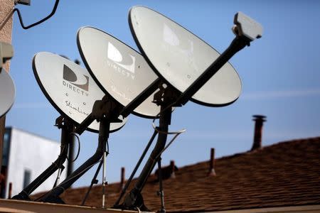 DirecTV satellite dishes are seen on an apartment roof in Los Angeles, California in this file photo taken May 18, 2014. REUTERS/Jonathan Alcorn/Files