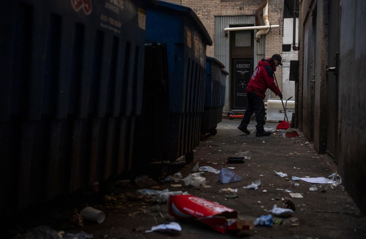 Oscar Garcia cleans up trash in a downtown Nashville alley on Nov. 13.