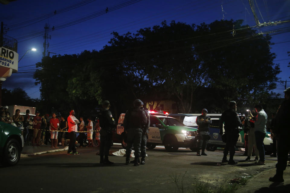Police work at the crime scene where the body of gunshot victim Daniel da Silva Gomes, 22, lies in the street in the Compensa neighborhood of Manaus in Amazonas state, Brazil, Tuesday, Nov 23, 2021. Murders in Brazil's Amazonas state have jumped 39% in the first nine months compared to the same period last year. That's the worst of any state in the country. (AP Photo/Edmar Barros)