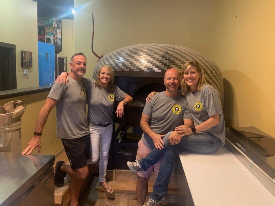 From right, Vinyl Pies owners Karen and Gary Goss pose with their business partners, Ashley Skipper and Marty Martin in front of the upcoming pizzeria's 7,000-pound brick oven, "Brick House."