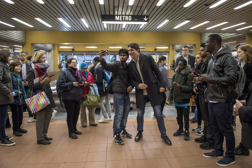 Canadian Prime Minister Justin Trudeau, center right, poses with commuters at a metro station in Montreal, Tuesday, Oct. 22, 2019. Trudeau won a second term in Canada's national elections Monday, losing the majority but delivering unexpectedly strong results despite having been weakened by a series of scandals that tarnished his image as a liberal icon. (Sean Kilpatrick/The Canadian Press via AP)