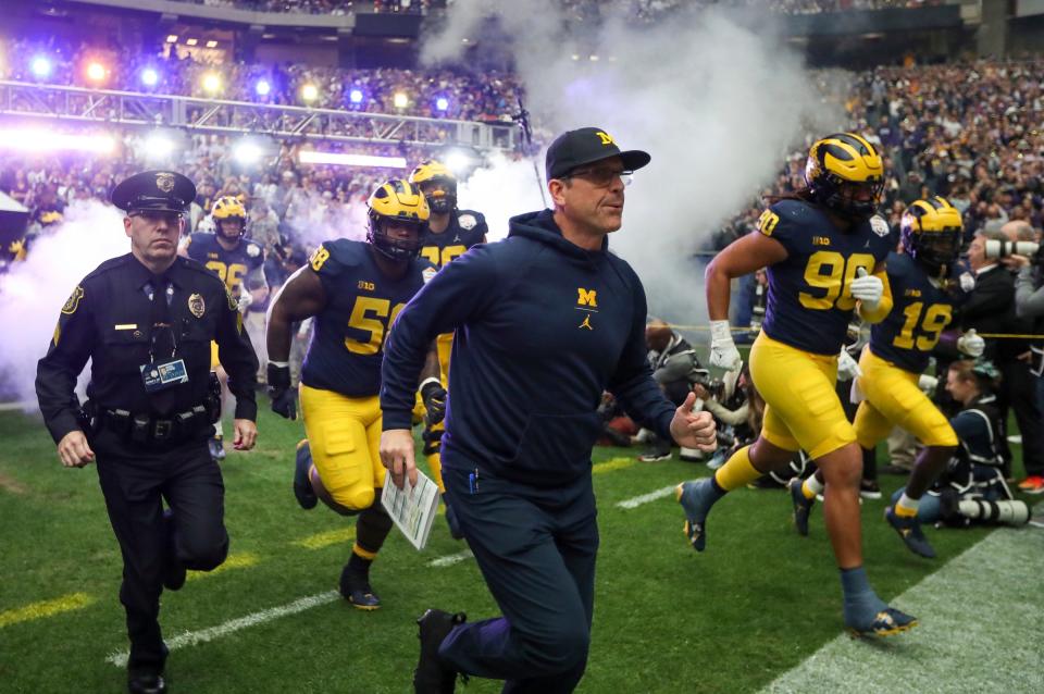 Michigan head coach Jim Harbaugh takes the field with the team at the start of the Fiesta Bowl on Saturday, Dec. 31 at State Farm Stadium in Glendale, Ariz.