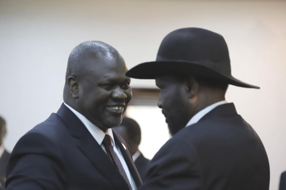 The president of South Sudan, Salva Kiir Mayardit, right, and Dr. Riek Machar, left, greet each other after swearing in ceremony in Juba, South Sudan Saturday, Feb. 22, 2020. South Sudan opened a new chapter in its fragile emergence from civil war Saturday as rival leaders formed a coalition government that many observers prayed would last this time around. (AP Photo)