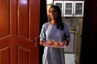 Nisha Rao, 28, a transgender woman who became country's first practicing lawyer, serves tea to her guests at home in Karachi