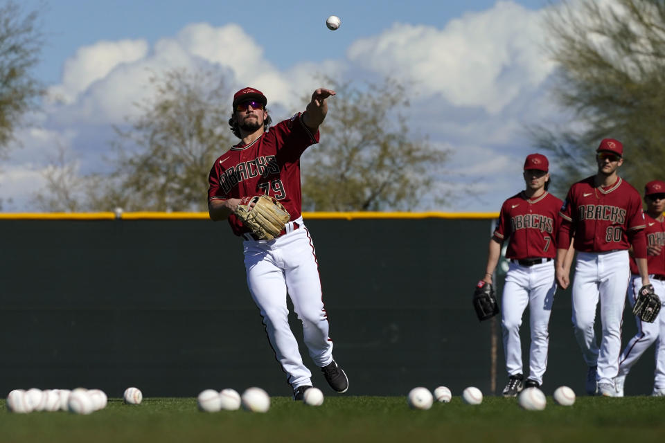 Arizona Diamondbacks right fielder Dominic Fletcher fields a ball during an MLB spring training baseball practice, Monday, Feb. 20, 2023, in Scottsdale, Ariz. (AP Photo/Matt York)