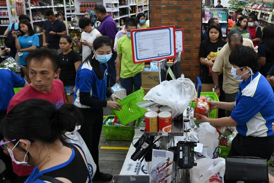 People queue to pay for groceries at a supermarket here on 3 April, 2020. (PHOTO: AFP via Getty Images)