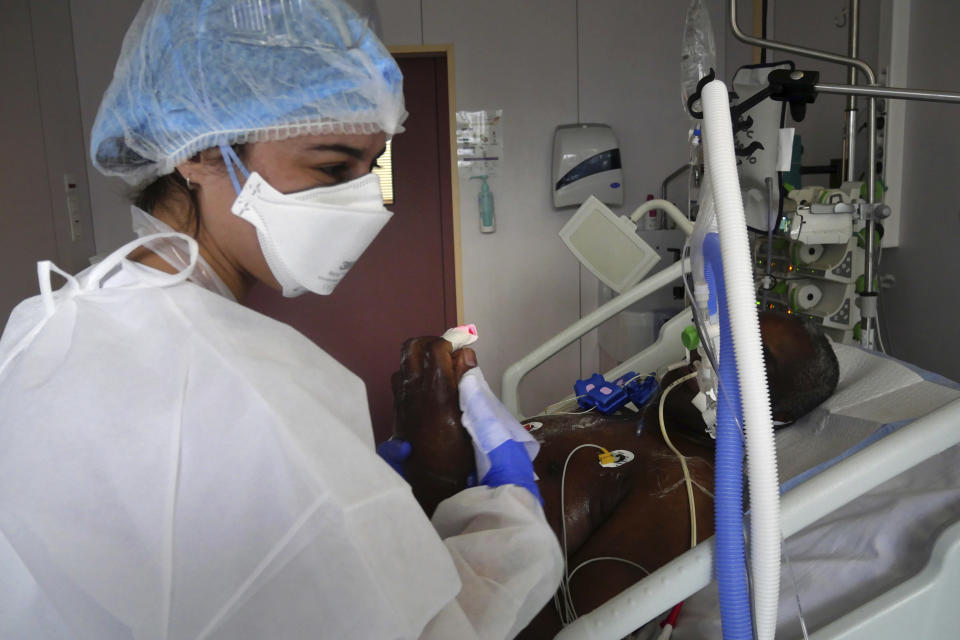 Nurse Stephanie Dias washes a patient affected by COVID-19 virus in the ICU unit at the Ambroise Pare clinic in Neuilly-sur-Seine, near Paris, Friday, March 19, 2021. French Prime Minister Jean Castex announced new coronavirus restrictions as the number of COVID-19 patients in intensive care units spikes. (AP Photo/Thibault Camus)