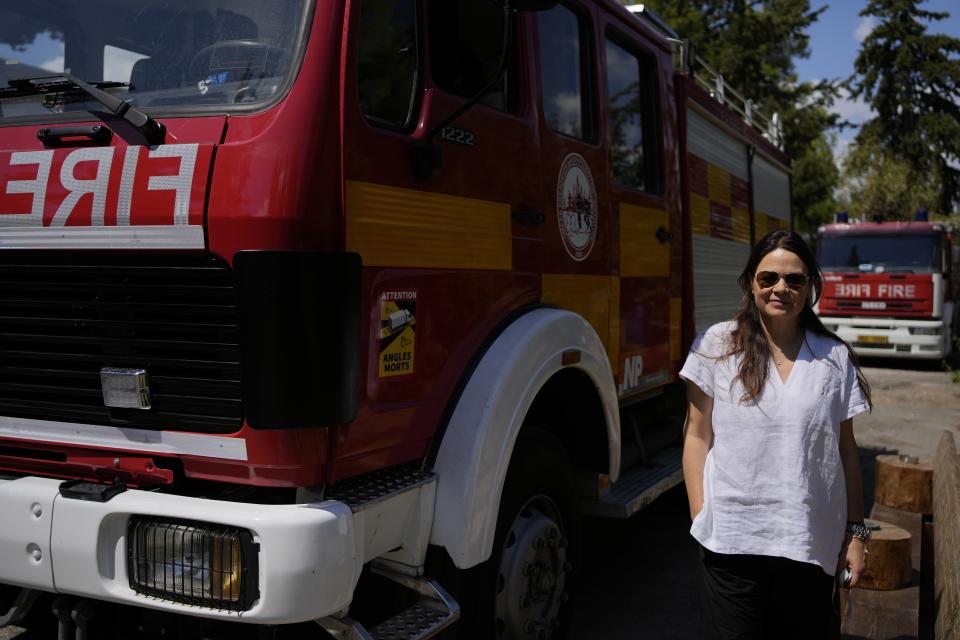 Local resident Melina Throuvala, a psychologist and one of the three who started the project for drone patrol, poses for a photograph in the local volunteer firefighters' unit in the northern suburb of Nea Erithrea, Athens, Greece, Friday, Aug. 11, 2023. Greece is plagued by hundreds of wildfires each summer. To protect their area from potentially deadly blazes, a group of residents from a suburb in northern Athens have joined forces to hire a company using long-range drones equipped with thermal imaging cameras and a sophisticated early warning system to catch fires before they can spread. (AP Photo/Thanassis Stavrakis)