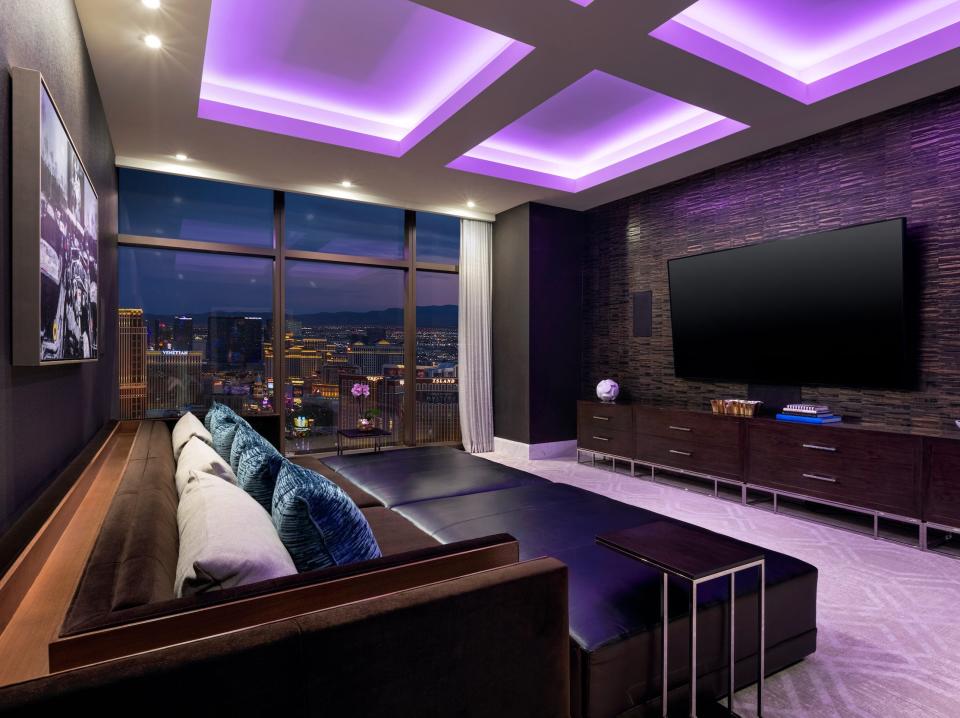 a tv in front of couches under purple lights