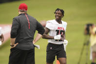 Atlanta Falcons wide receiver Calvin Ridley, right, laughs with head coach Arthur Smith, left, during NFL football practice Friday, July 30, 2021, in Flowery Branch, Ga. (AP Photo/Brynn Anderson)