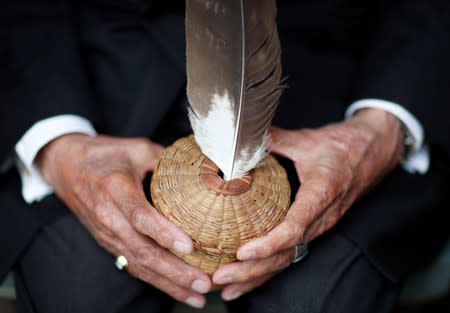 Charles Norman Shay, 94, a Penobscot Native American Indian WWII veteran, poses holding an eagle feather in a basket made by his mother Florence as he attends an interview with Reuters in Bretteville l'Orgueilleuse