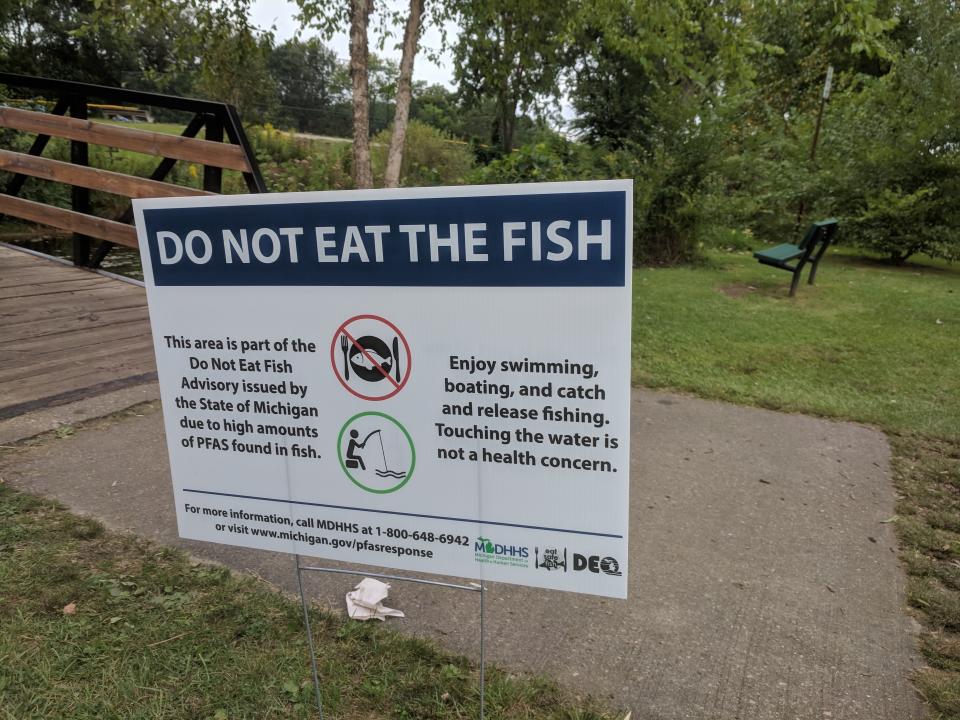 A sign at Milford, Michigan's Central Park advises anglers not to eat fish caught from Hubbell Pond or the Huron River, due to potentially harmful PFAS contamination, in this Sept. 8, 2018 photo.