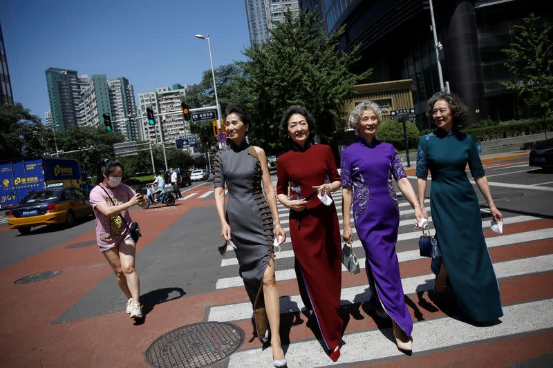 Las integrantes del grupo de abuelas modelo chinas "Glamma Beijing" graban un video paseando por la calles del céntrico distrito financiero de Pekín con trajes tradicionales.