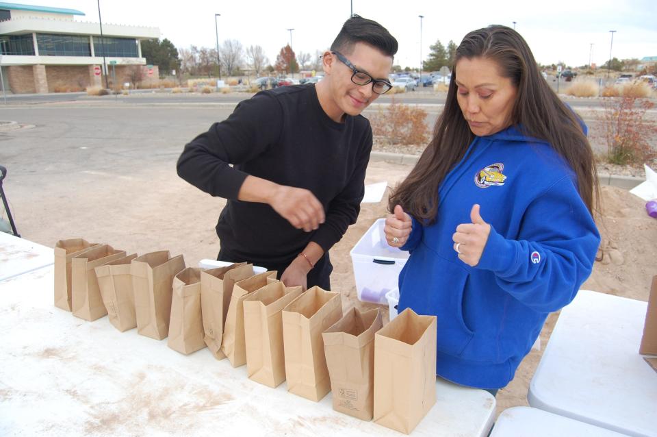 Dante Stevens and Christina Holden of the San Juan College Campus Activities Board place candles in sand-filled sacks on Dec. 1 in preparation for this weekend's annual luminarias display on the college campus in Farmington.