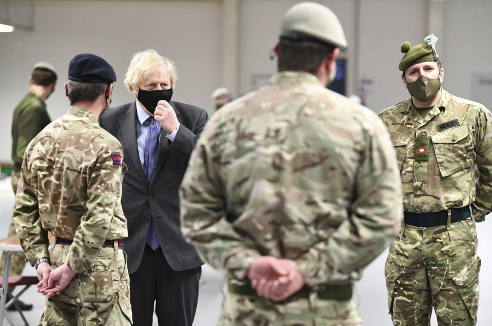 Britain's Prime Minister Boris Johnson meets with troops setting up a vaccination centre in the Castlemilk district of Glasgow, on his one day visit to Scotland, Thursday, Jan. 28, 2021. Johnson is facing accusations that he is not abiding by lockdown rules as he makes a trip to Scotland on Thursday to laud the rapid rollout of coronavirus vaccines across the United Kingdom. (Jeff Mitchell/Pool Photo via AP)
