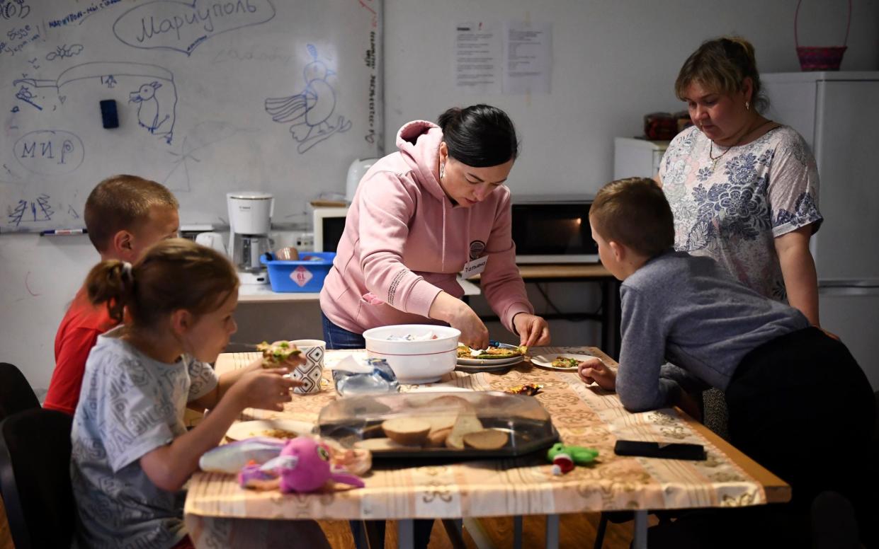 Volunteer Tatjana (C) serving food for refugees at a€Friends of Mariupolrefugee shelter in Narva, Estonia - Sergei Stepanov for The Telegraph