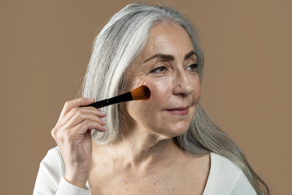 TikTok Beauty Trends For Women Over 40: older woman applies bronzer to cheeks