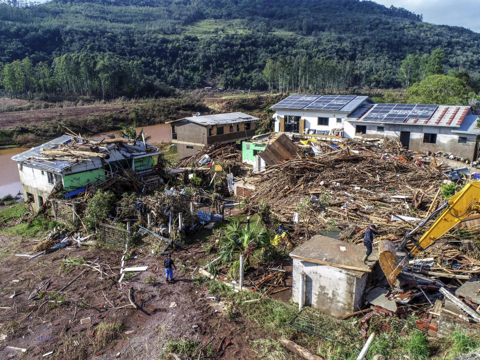 Residents walks amid destroyed houses after floods caused by a deadly cyclone in Mucum, Rio Grande do Sul state, Brazil, Wednesday, Sept. 6, 2023. An extratropical cyclone in southern Brazil caused floods in several cities. (AP Photo/Wesley Santos)