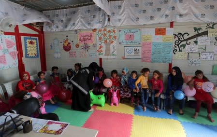 Displaced Syrian refugee children wait to receive psychological support at a mobile clinic, in north Azaz