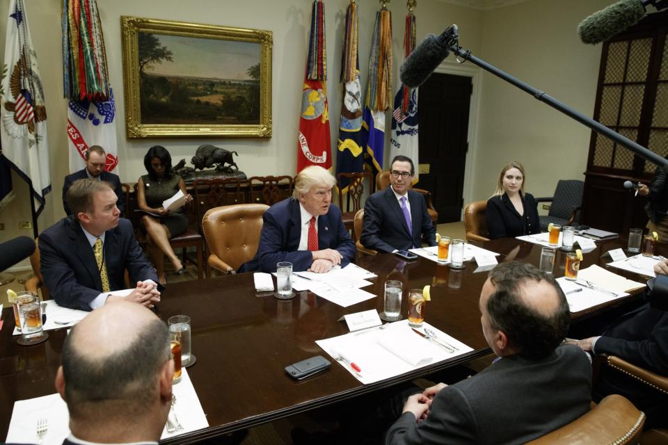 President Trump, flanked by Budget Director Mick Mulvaney, left, and Treasury Secretary Steve Mnuchin. (Photo: Evan Vucci/AP)