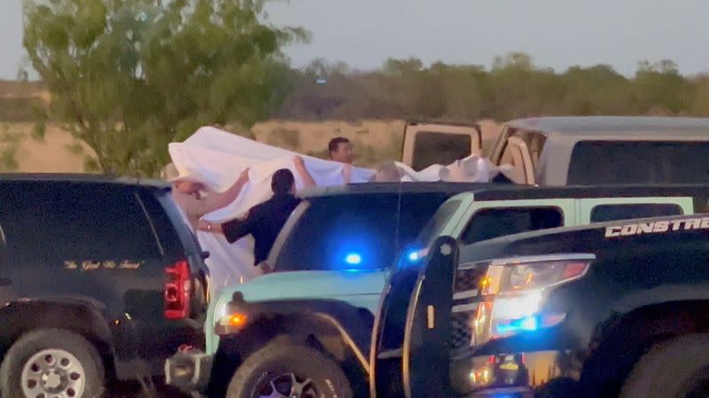 Law enforcement officials work after two migrants suffocated to death aboard a freight train that got derailed, in Uvalde