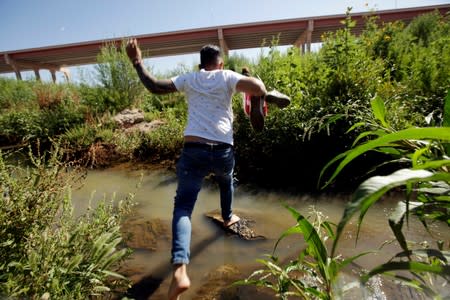 FILE PHOTO: A migrant from Cuba is seen on the banks of the Rio Bravo river as he crosses illegally into the United States to turn himself in to request asylum in El Paso, Texas, as seen from Ciudad Juarez